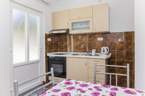 una piccola cucina con lavandino e piano cottura di Apartments by the sea Zuronja, Peljesac - 14095 a Putniković