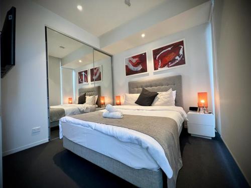 - une chambre avec 2 lits et un grand miroir dans l'établissement Luxury 2 Bedroom Suite near Adelaide with a car park, à Broadview