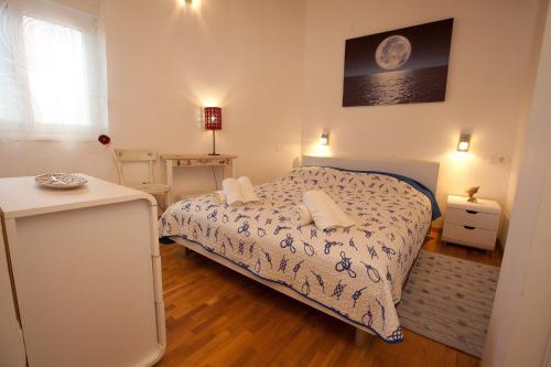 um pequeno quarto com uma cama e uma mesa em Apartments with a swimming pool Preko, Ugljan - 14163 em Preko