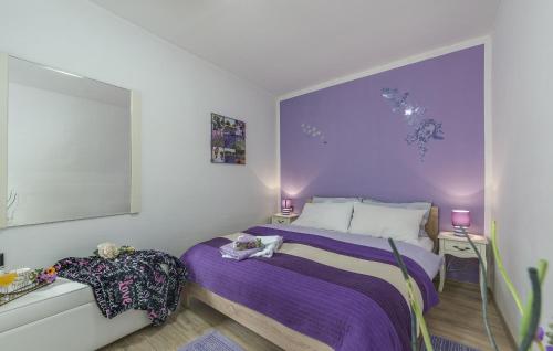 a bedroom with a purple bed and two night stands at Family friendly apartments with a swimming pool Vodnjan, Fazana - 14159 in Vodnjan