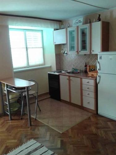 ラザナッツにあるApartments by the sea Razanac, Zadar - 14179のテーブルと白い冷蔵庫のあるキッチン