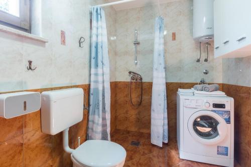 La salle de bains est pourvue de toilettes et d'un lave-linge. dans l'établissement Family friendly house with a swimming pool Lindar, Central Istria - Sredisnja Istra - 14189, à Pazin