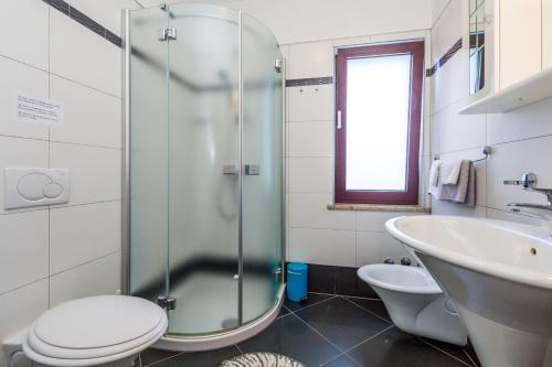 La salle de bains est pourvue d'une douche, de toilettes et d'un lavabo. dans l'établissement Apartments with a swimming pool Lovran, Opatija - 14196, à Lovran