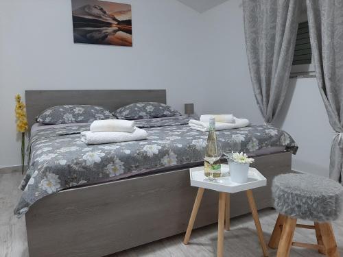 - une chambre avec un lit et une table avec une bouteille de vin dans l'établissement Apartments with a parking space Vrsi, Zadar - 14211, à Vrsi