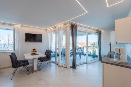 a kitchen and dining room with a table and chairs at Apartments by the sea Preko, Ugljan - 14244 in Preko