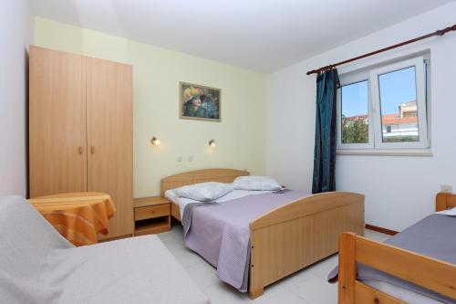 sypialnia z 2 łóżkami i oknem w obiekcie Apartments by the sea Barbat, Rab - 14247 w Rabie