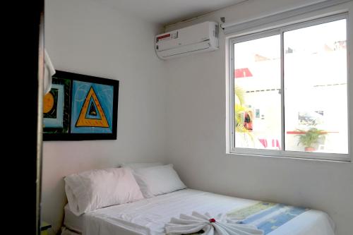 a small bedroom with a bed and a window at Comodas Habitaciones Hotel Bucaros in Espinal