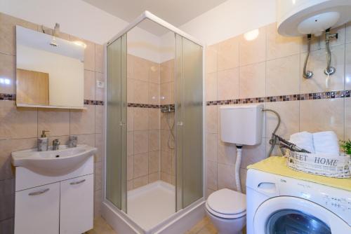 ein Bad mit einer Dusche, einem WC und einem Waschbecken in der Unterkunft Apartments with a parking space Marina, Trogir - 14258 in Marina