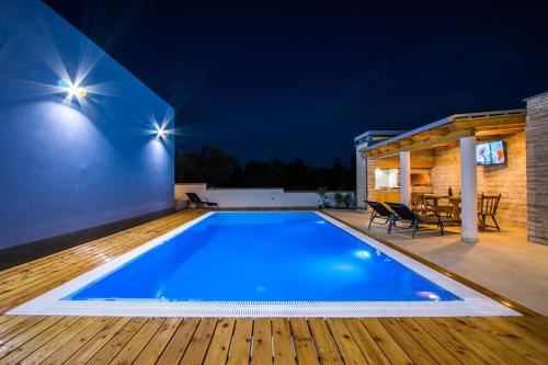 una piscina in un cortile posteriore di notte di Apartment Verunic 14286d a Veli Rat