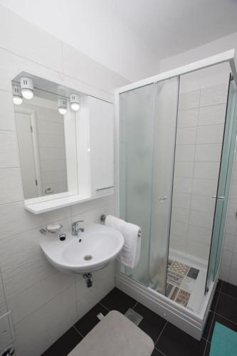 a white bathroom with a sink and a shower at Apartment Verunic 14286d in Veli Rat