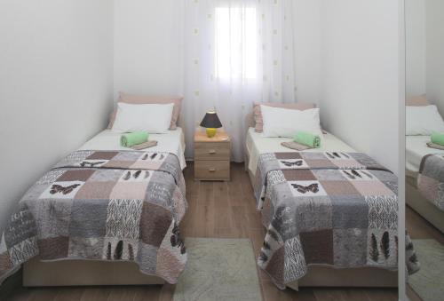 1 Schlafzimmer mit 2 Betten und einem Nachttisch in der Unterkunft Apartments by the sea Razanj, Rogoznica - 14357 in Rogoznica