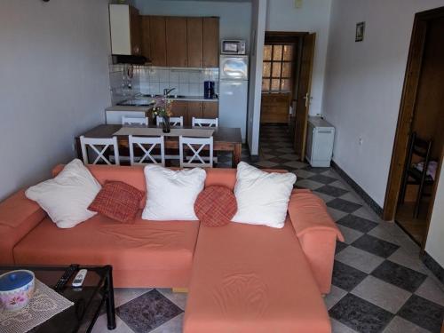 sala de estar con sofá naranja y cocina en Apartments by the sea Prizba, Korcula - 14385, en Prizba