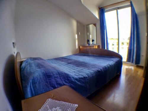 Un dormitorio con una cama azul y una ventana en Apartments by the sea Prizba, Korcula - 14385, en Prizba