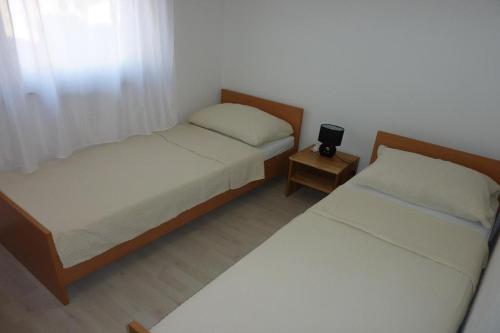 a bedroom with two beds and a small night stand at Apartments with a parking space Vir - 14389 in Vir