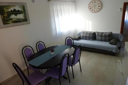 a living room with a table and purple chairs at Apartments with a parking space Vir - 14389 in Vir