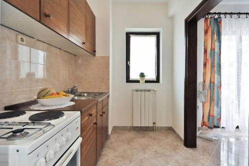 ノヴァリャにあるFamily friendly apartments with a swimming pool Novalja, Pag - 14394のキッチン(コンロ、フルーツボウル付)