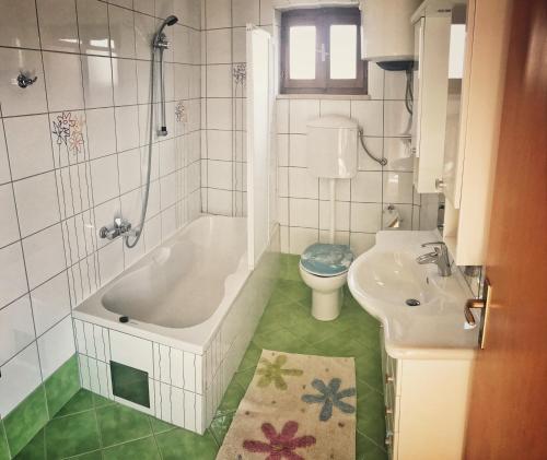 a bathroom with a tub and a toilet and a sink at Apartments by the sea Povlja, Brac - 14399 in Povlja