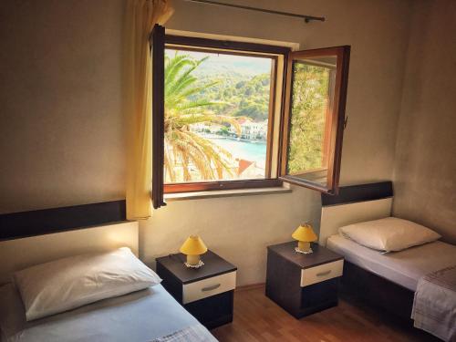 a bedroom with two beds and a large window at Apartments by the sea Povlja, Brac - 14399 in Povlja
