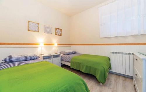 duas camas num quarto com lençóis verdes em Apartments with a parking space Rijeka - 14403 em Rijeka