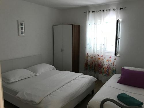a bedroom with two beds and a window at Apartments by the sea Stupin Celine, Rogoznica - 14416 in Podglavica