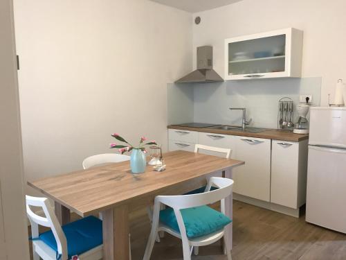 a small kitchen with a wooden table and chairs at Apartments by the sea Stupin Celine, Rogoznica - 14416 in Podglavica