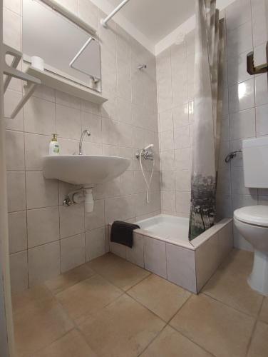 a bathroom with a sink and a tub and a toilet at Apartments by the sea Tisno, Murter - 14410 in Tisno