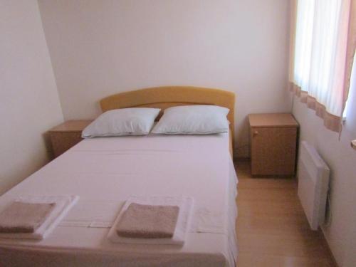- une petite chambre avec un lit blanc et 2 oreillers dans l'établissement Apartments by the sea Tisno, Murter - 14410, à Tisno