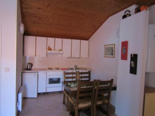 - une cuisine avec des appareils blancs, une table et des chaises dans l'établissement Apartments by the sea Tisno, Murter - 14410, à Tisno