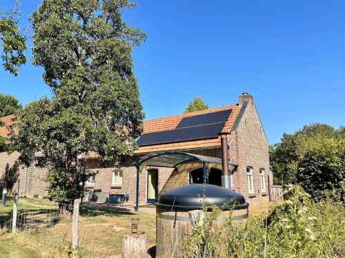 stary ceglany dom z dużą czarną kopułą w obiekcie Coachman s house with hot tub w mieście Sint Odiliënberg