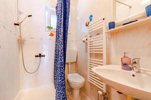 y baño con ducha, aseo y lavamanos. en Apartments and rooms with parking space Mali Ston (Peljesac) - 14434, en Mali Ston