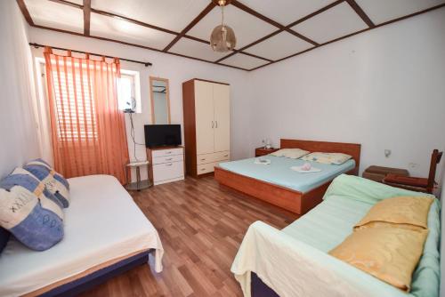 a room with two beds and a television in it at Holiday house with a parking space Kustici, Pag - 14438 in Zubovići