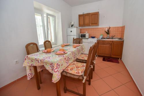 a kitchen with a table and chairs and a kitchen with a table and chairsktop at Holiday house with a parking space Kustici, Pag - 14438 in Zubovići