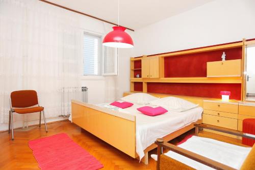 1 dormitorio con cama, escritorio y silla en Apartments by the sea Sumpetar, Omis - 14450 en Jesenice