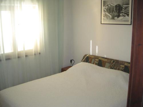 een bed in een kamer met een raam en een sprei bij Holiday house with a parking space Kozino, Zadar - 14464 in Petrcane