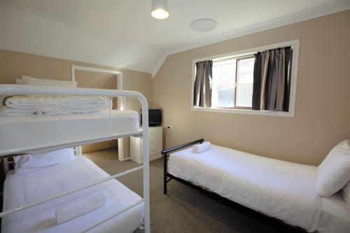 een kamer met 2 stapelbedden en een raam bij Blizzard Bunny Lodge 43 Gippsland Street in Jindabyne
