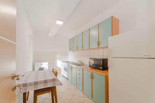 uma cozinha com um frigorífico e uma mesa em Apartments with a parking space Privlaka, Zadar - 14492 em Privlaka