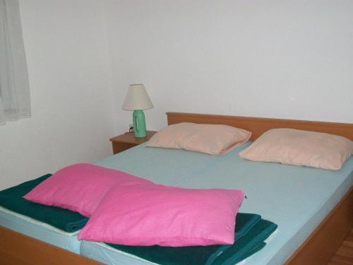 a bed with two pillows on top of it at Apartments with a parking space Starigrad, Paklenica - 14507 in Starigrad-Paklenica