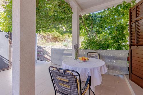 a white table with chairs on a patio at Apartments by the sea Cove Vela Stiniva, Hvar - 14511 in Zastražišće