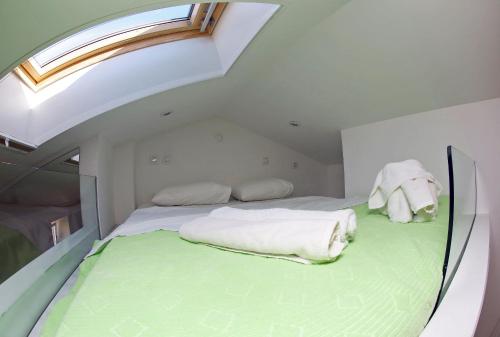 a large bed in a room with a skylight at Apartments with WiFi Zadar - 14529 in Zadar