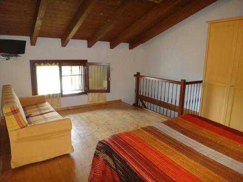 ein Schlafzimmer mit einem Bett, einem Stuhl und einem TV in der Unterkunft Agriturismo San Valentino in Castellarano
