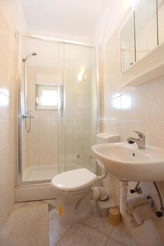 a bathroom with a toilet and a sink and a shower at Apartments by the sea Slatine, Ciovo - 14541 in Slatine