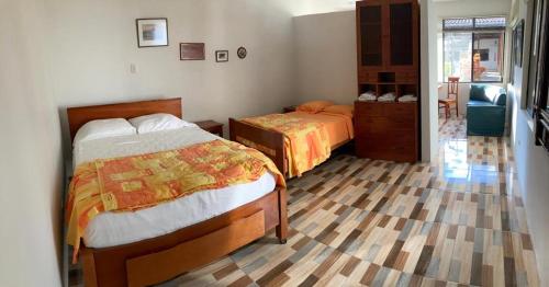 a bedroom with two beds and a chair in it at Hermoso apartamento en condominio privado in Iquitos