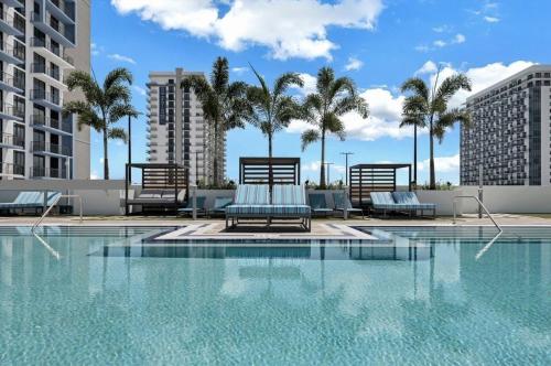uma piscina com cadeiras e palmeiras num edifício em DOWNTOWN DORAL, FLORIDA. NEW CONDO STYLE RESORT. em Miami