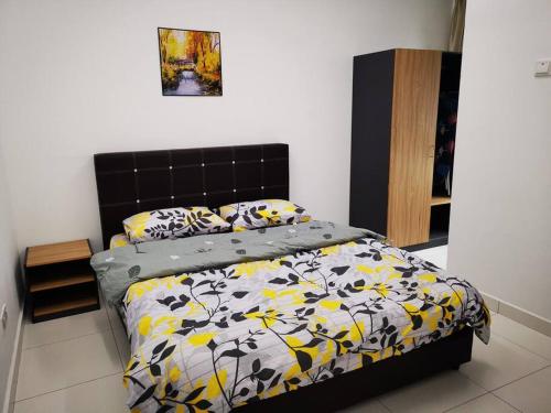 1 dormitorio con 1 cama con edredón negro y amarillo en D'sarang Cinta Homestay Swimming Pool Melaka, en Ayer Keroh