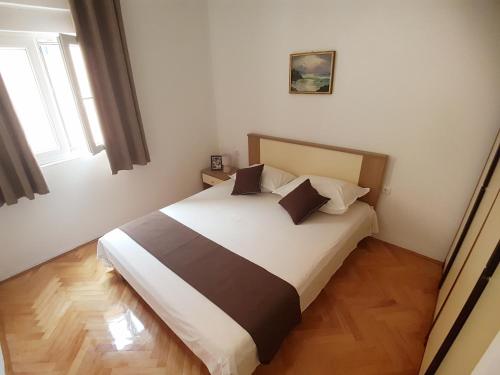 a bedroom with a bed with white and brown sheets at Apartments by the sea Marina, Trogir - 14191 in Marina