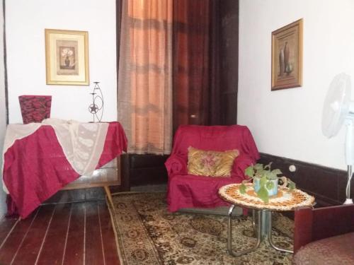a living room with a red chair and a table at Casa dragão in Porto