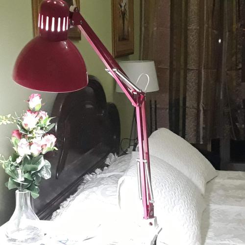 a red lamp sitting on top of a bed at Casa dragão in Porto