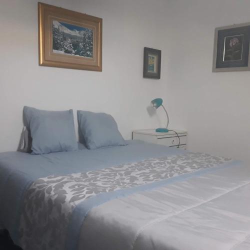 a bedroom with a bed with a lamp on a table at Casa dragão in Porto