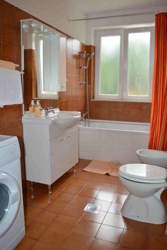 a bathroom with a toilet and a sink and a tub at Apartments with parking space Punat, Krk - 16307 in Punat