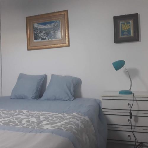 a bedroom with a bed with a lamp and a dresser at Casa dragão in Porto